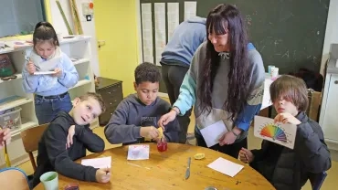 Un groupe d'enfants et leur animatrice peignent